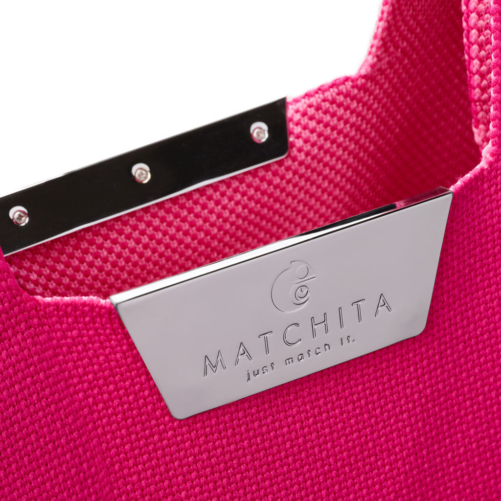 Близък кадър на отворено метално магнитно закопчаване с лого и вътрешност от тъкан полиестер