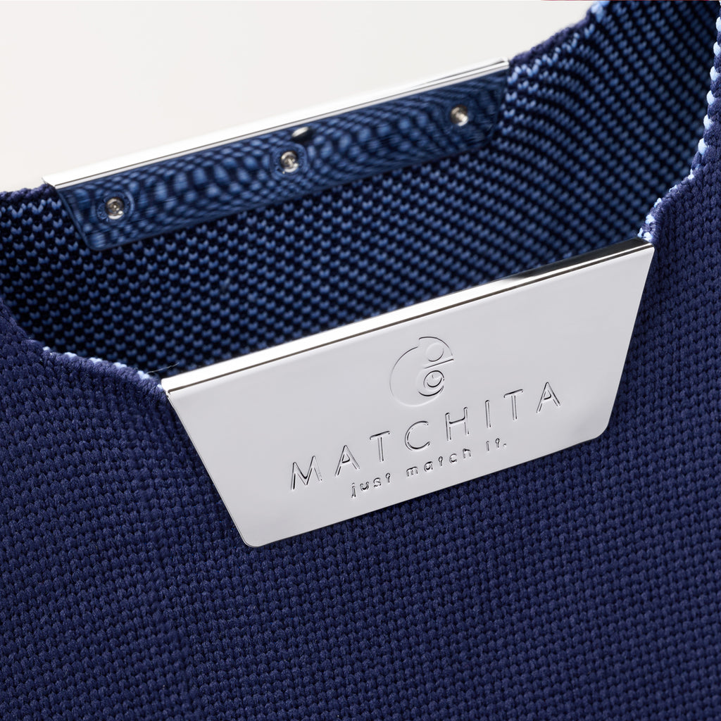 Близък кадър на метално магнитно закопчаване с лого и вътрешност от тъкан полиестер